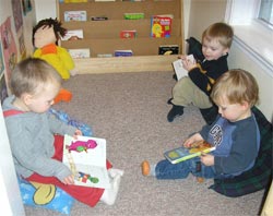 3 toddler boys reading in book area at Children's Time Child Care