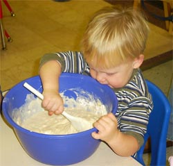 Child stirring play dough batter