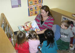 Children's Time Teacher reading to 4 children